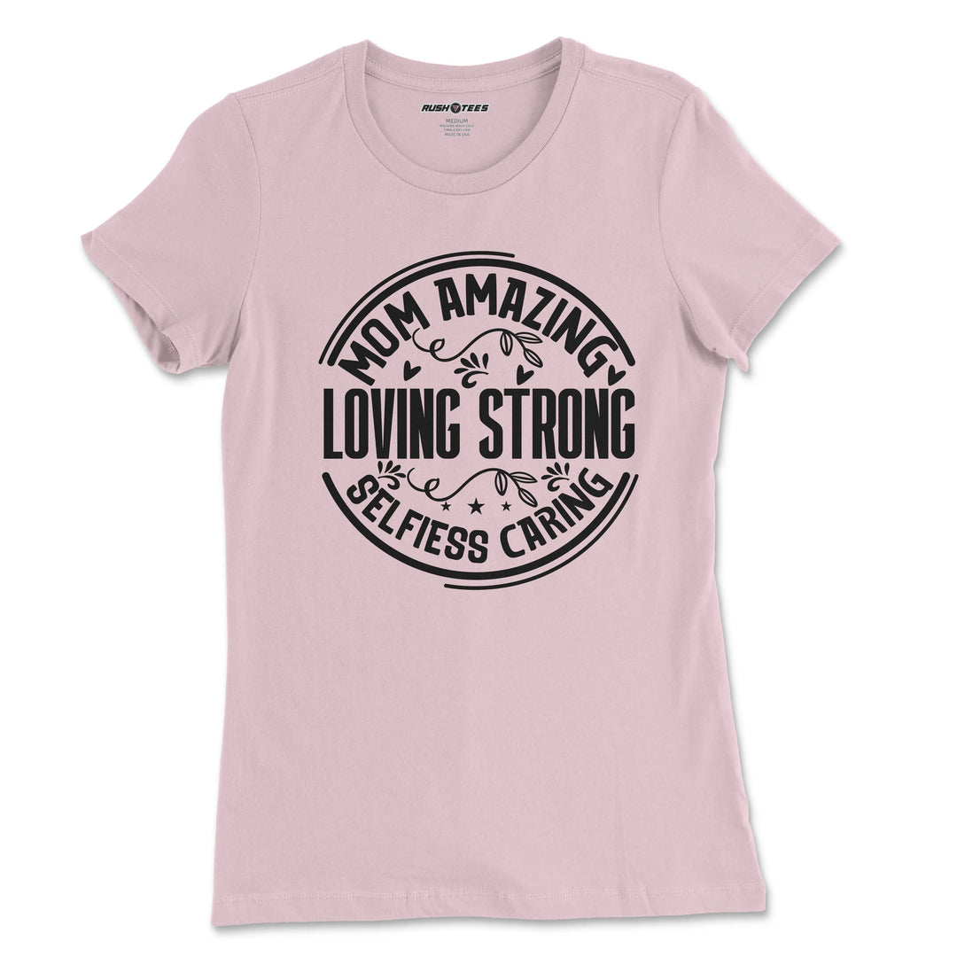Pastel pink t-shirt featuring bold typography: 'Mom Amazing Loving Strong Selfless Caring', ideal for Mother's Day gifts.