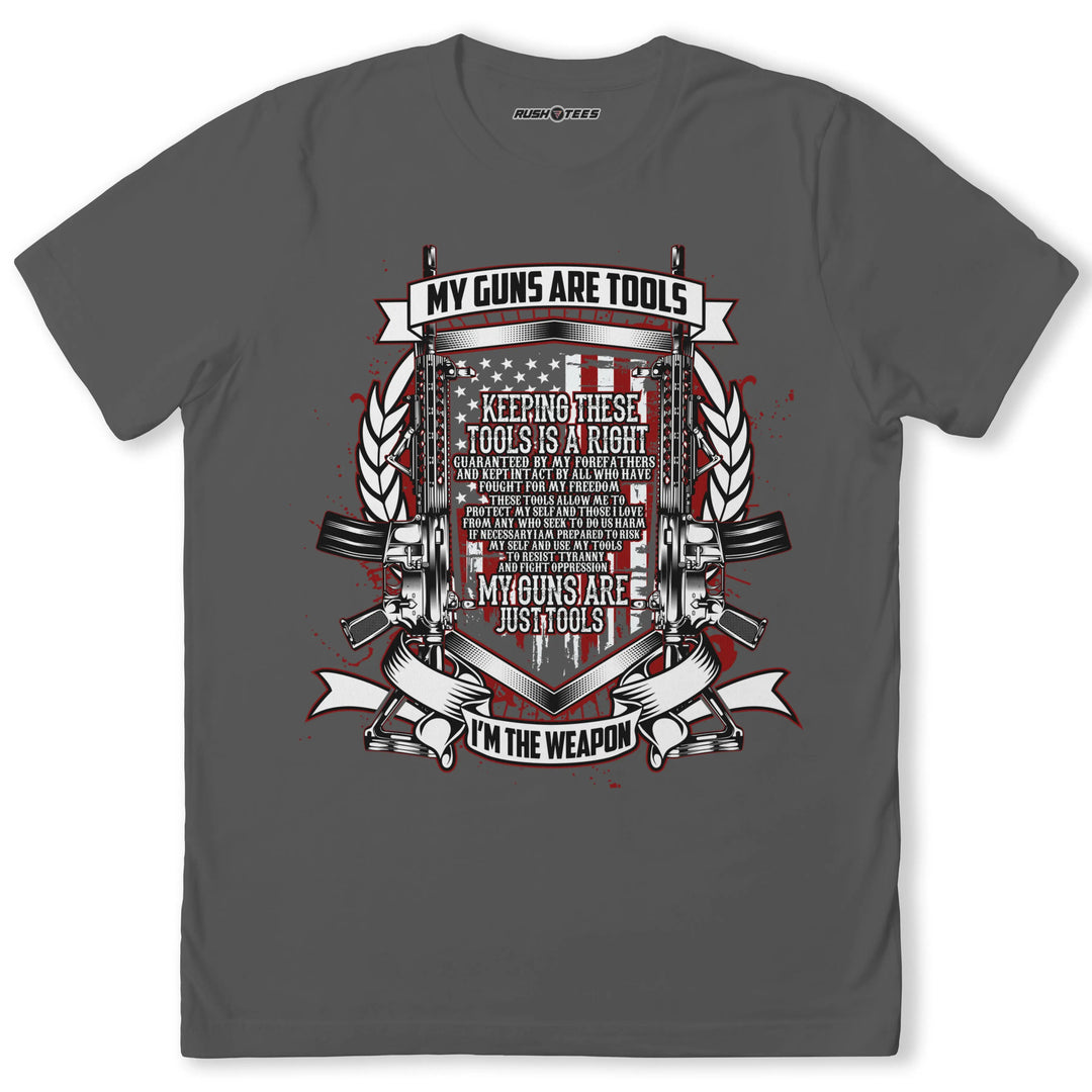 Grey t-shirt featuring 'MY GUNS ARE TOOLS' graphic, American flag background, and gun illustrations.